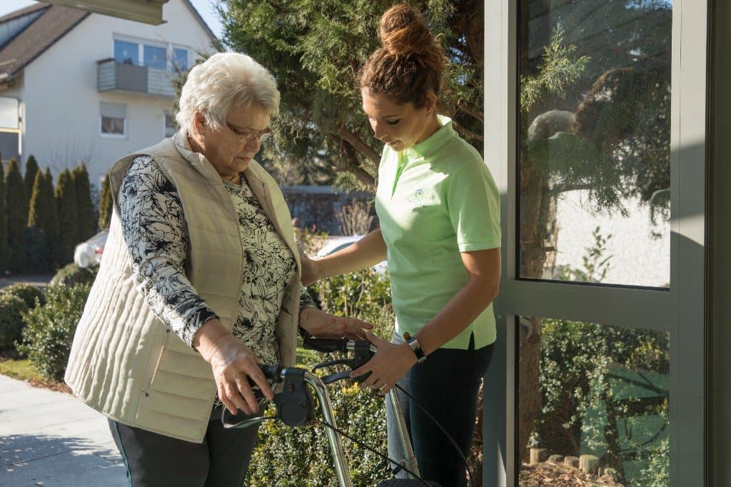Seniorin zu Hause mit Unterstützung im Alltag, Symbol für den richtigen Zeitpunkt für einen Pflegedienst